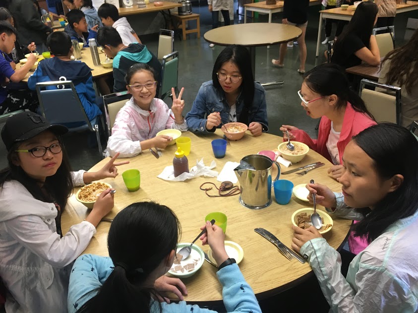 Group of students sitting at a table eating Open Gallery